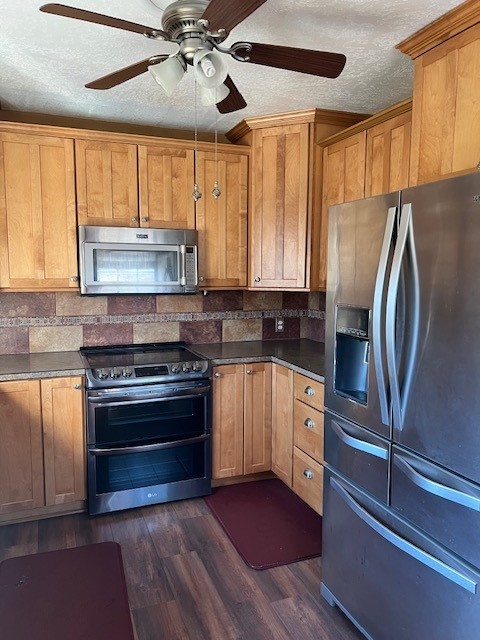 kitchen featuring ceiling fan, stainless steel appliances, backsplash, a textured ceiling, and dark hardwood / wood-style flooring