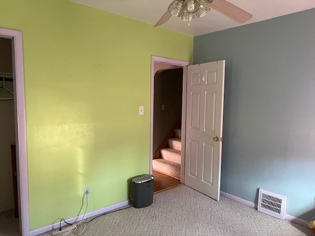 unfurnished bedroom featuring ceiling fan, light colored carpet, and a closet