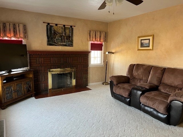 living room with ceiling fan, carpet, and a brick fireplace