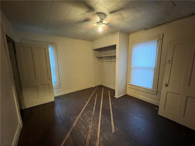 unfurnished bedroom featuring a closet, ceiling fan, and dark hardwood / wood-style flooring