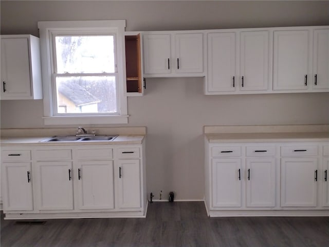 kitchen with white cabinetry, a healthy amount of sunlight, sink, and dark hardwood / wood-style flooring