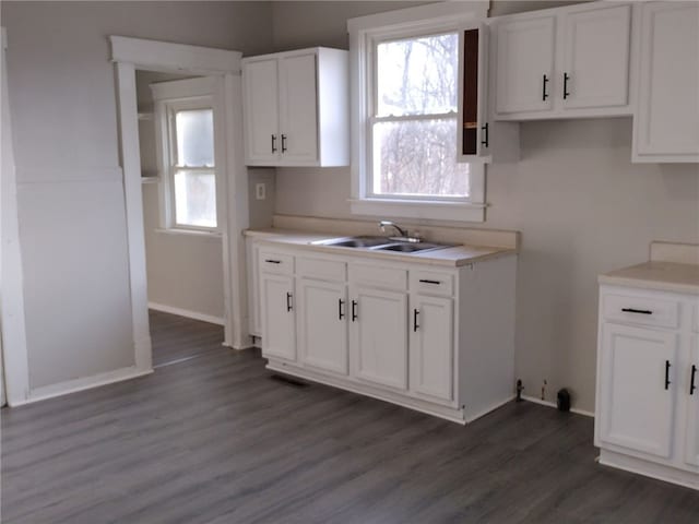 kitchen with sink, white cabinetry, dark hardwood / wood-style floors, and a healthy amount of sunlight