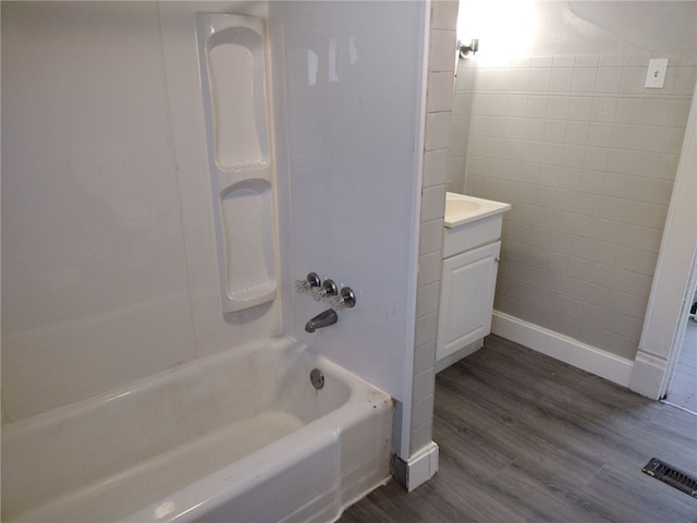 bathroom with vanity, hardwood / wood-style floors, and shower / bathtub combination