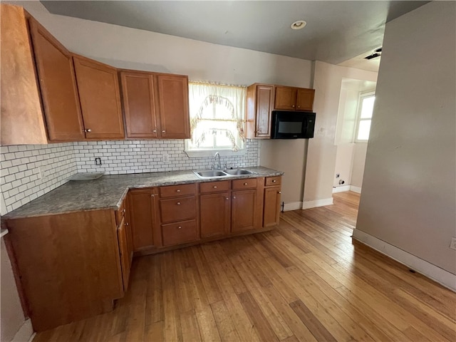 kitchen featuring backsplash, sink, and light wood-type flooring