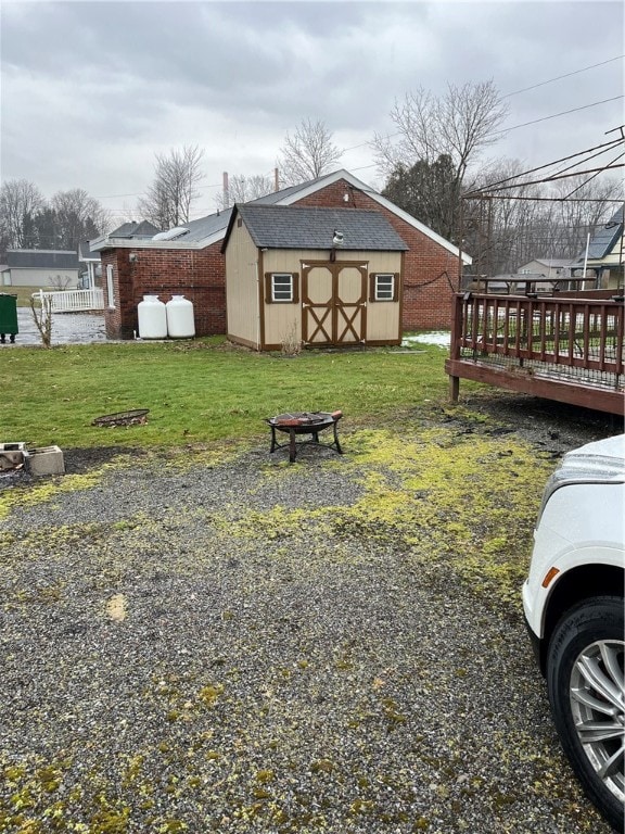 view of yard featuring a storage unit and a wooden deck