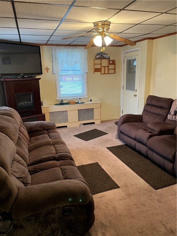 living room with ceiling fan, a drop ceiling, and carpet