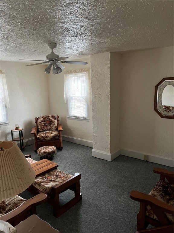 carpeted living room featuring ceiling fan and a textured ceiling