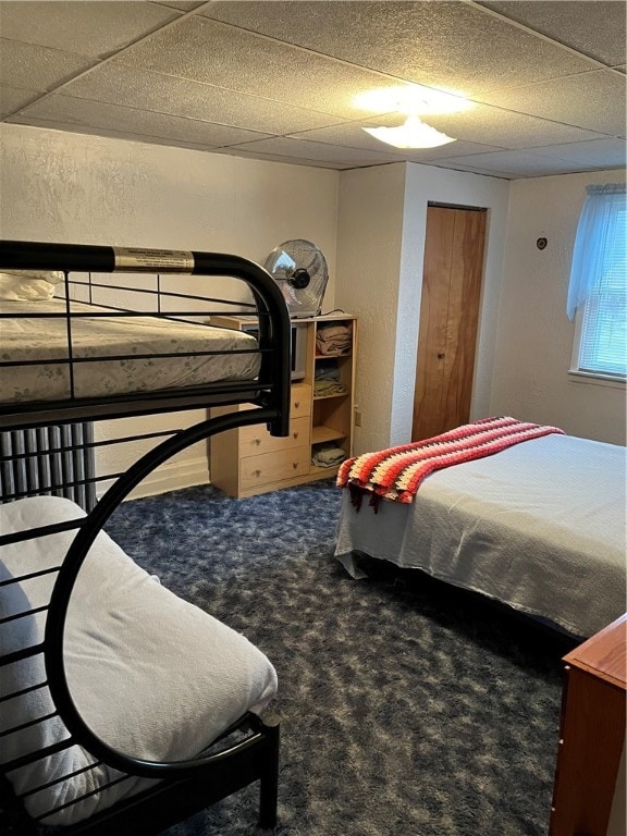 bedroom featuring a paneled ceiling and carpet floors