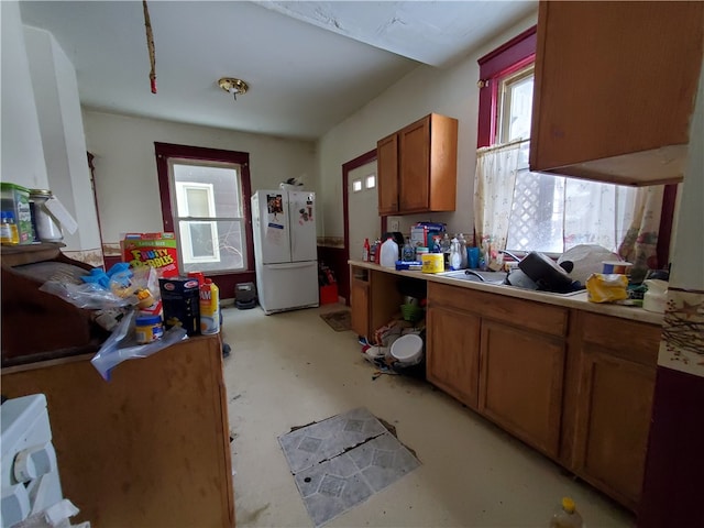 kitchen with a wealth of natural light, sink, and white refrigerator