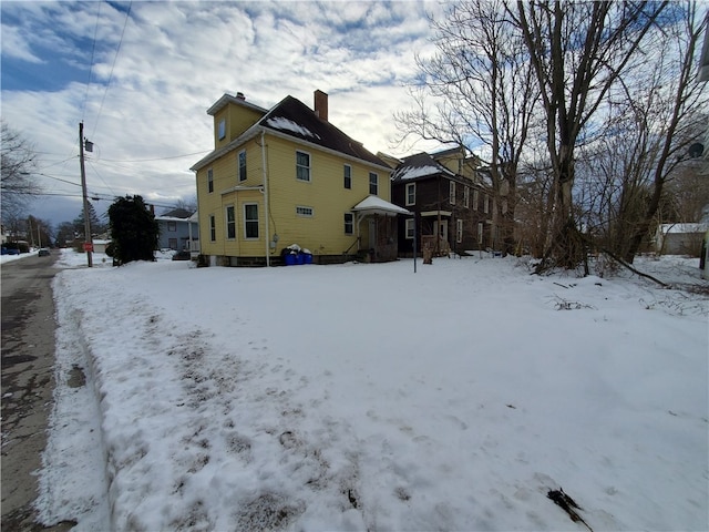 view of snow covered back of property