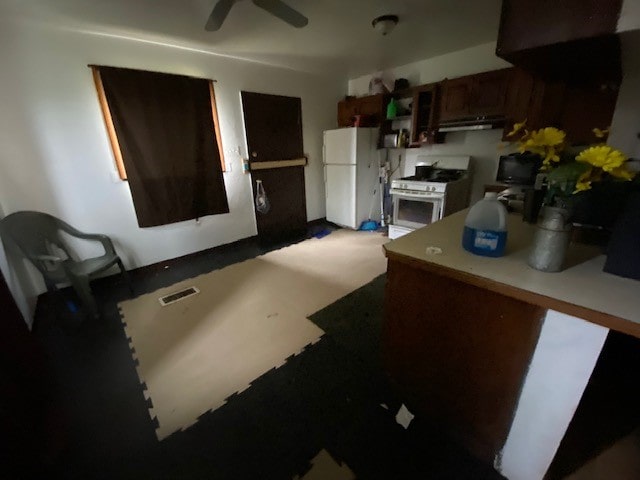 kitchen featuring white appliances, ceiling fan, dark brown cabinetry, and kitchen peninsula