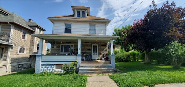 view of front facade with a front lawn and covered porch