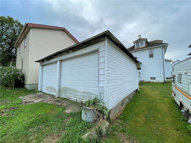 view of property exterior with a yard and a garage