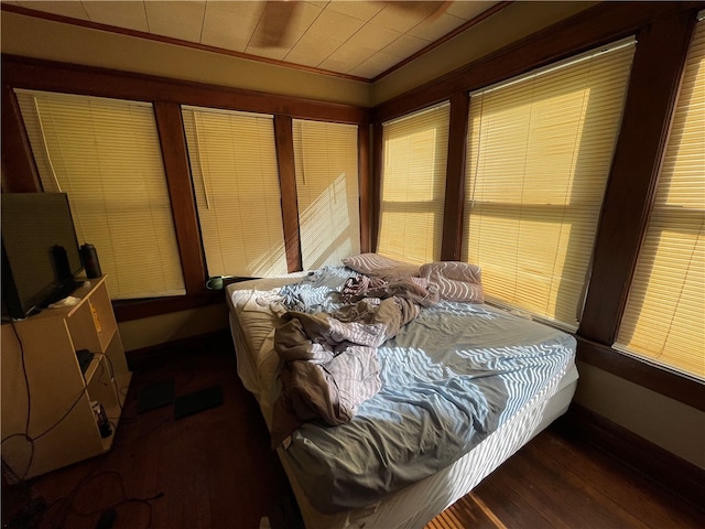 bedroom featuring crown molding and dark hardwood / wood-style floors