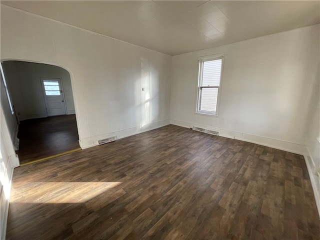 unfurnished room with dark wood-type flooring and plenty of natural light