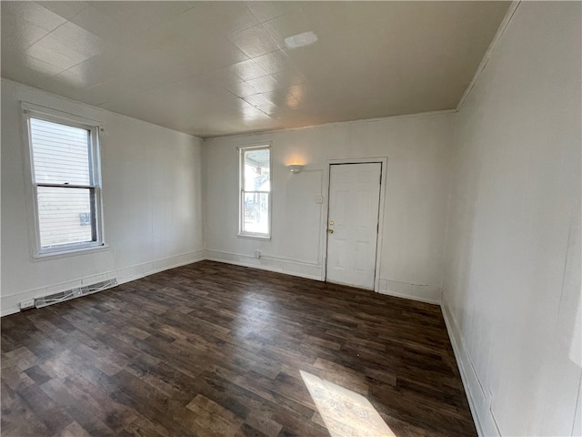 spare room with dark wood-type flooring and ornamental molding