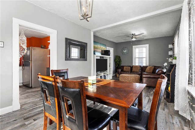 dining area featuring light hardwood / wood-style flooring, ceiling fan, and a textured ceiling