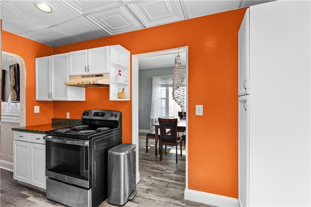 kitchen featuring dark stone counters, white cabinetry, light hardwood / wood-style flooring, and electric range