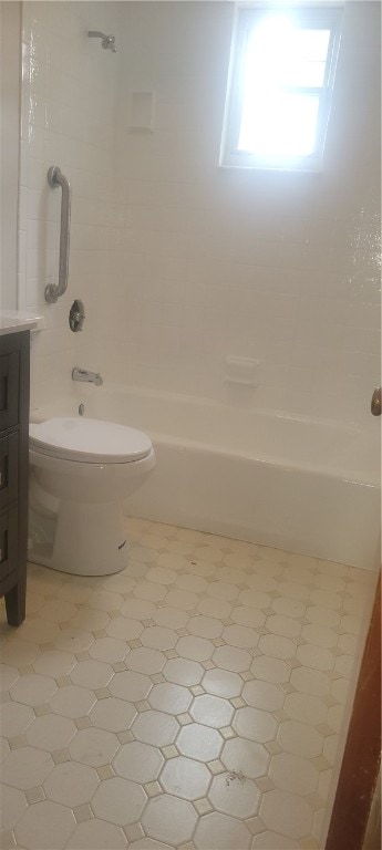 full bathroom featuring tiled shower / bath combo, vanity, toilet, and tile floors