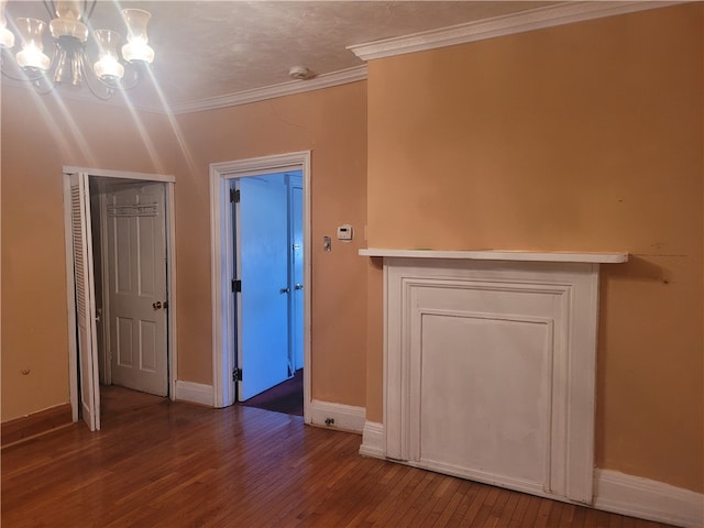 interior space with ornamental molding, a notable chandelier, and dark wood-type flooring