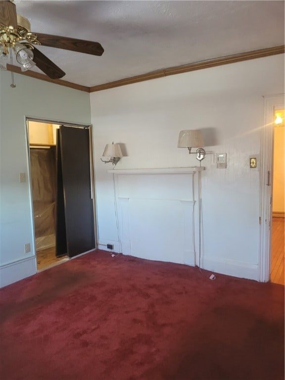 unfurnished bedroom with ceiling fan, crown molding, carpet floors, and a closet