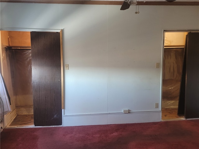 unfurnished bedroom featuring ceiling fan, dark carpet, and a closet