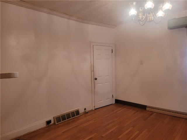 spare room featuring dark hardwood / wood-style flooring, a notable chandelier, ornamental molding, and a baseboard radiator