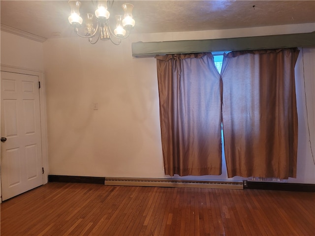 unfurnished room with dark hardwood / wood-style flooring, an inviting chandelier, and a baseboard heating unit