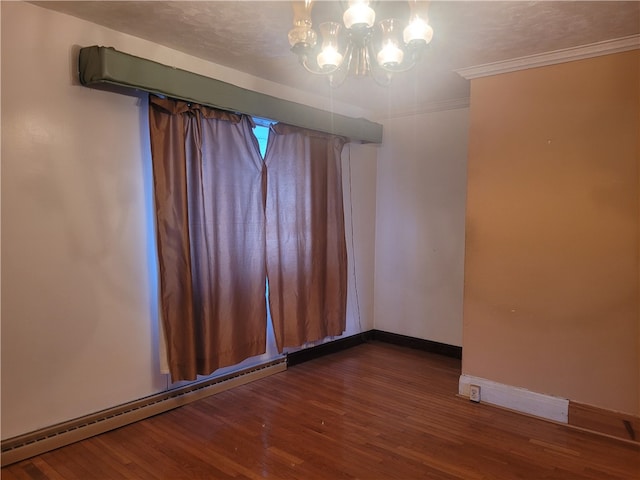 empty room featuring dark hardwood / wood-style flooring, a notable chandelier, ornamental molding, and a baseboard radiator