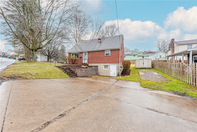 back of property featuring a storage unit and a lawn