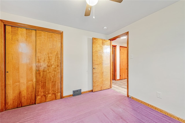 unfurnished bedroom featuring light carpet, a closet, and ceiling fan