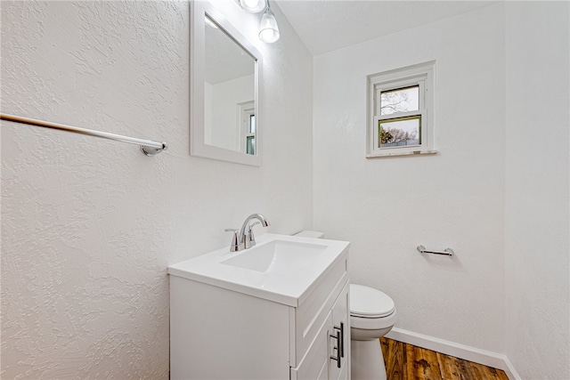 bathroom featuring oversized vanity, toilet, and wood-type flooring