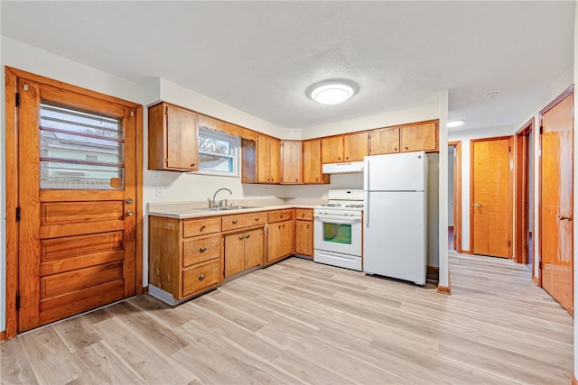 kitchen with white appliances, a textured ceiling, light hardwood / wood-style floors, and sink