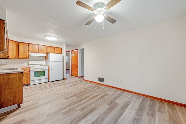 kitchen with ceiling fan, white appliances, sink, and light hardwood / wood-style floors