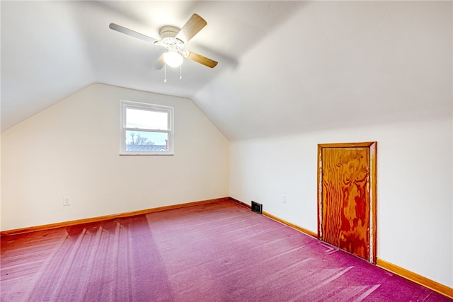 additional living space featuring ceiling fan, dark carpet, and lofted ceiling