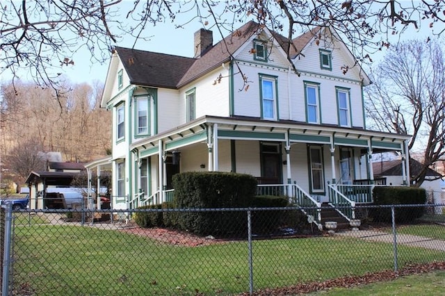 victorian-style house featuring a porch and a front lawn