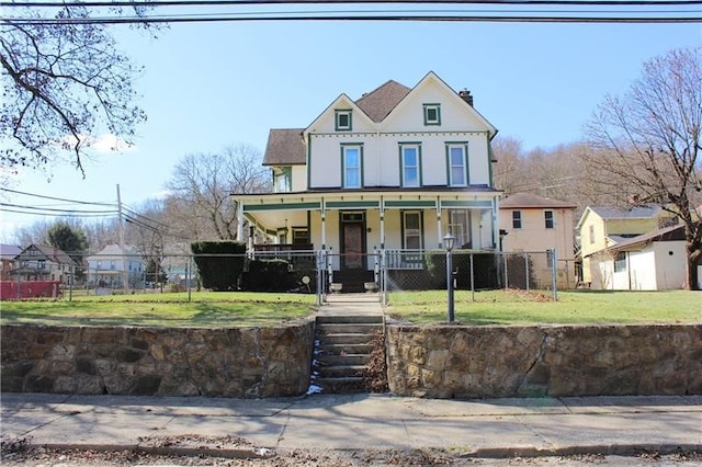 victorian home featuring a porch and a front lawn