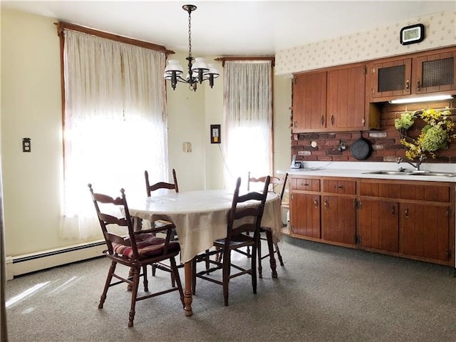 dining space featuring a notable chandelier, a baseboard radiator, and sink