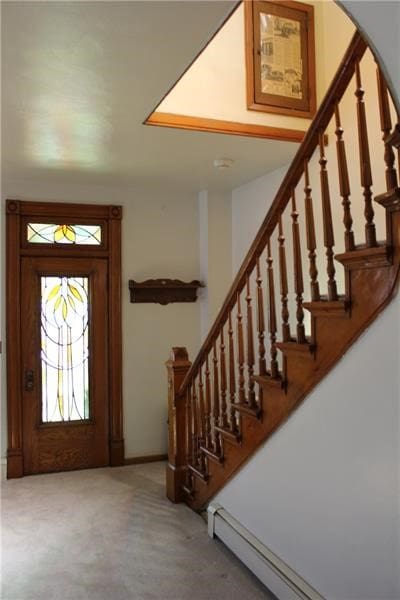 foyer entrance featuring light carpet and a baseboard heating unit