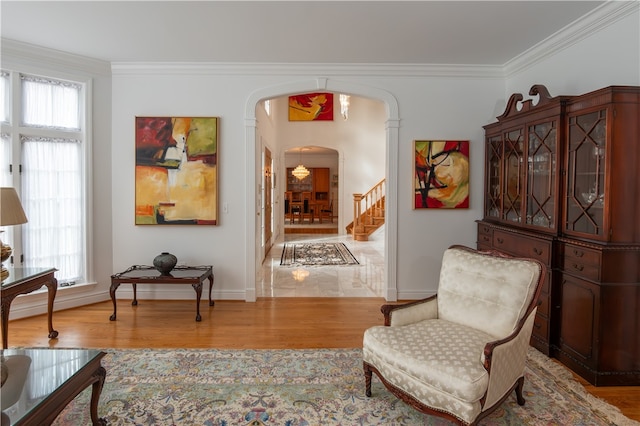 living area with ornamental molding and light hardwood / wood-style flooring