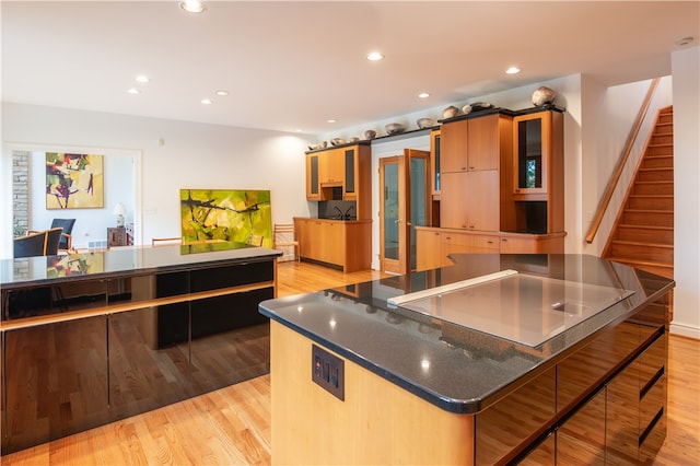 kitchen featuring a center island, dark stone countertops, light wood-type flooring, and a barn door