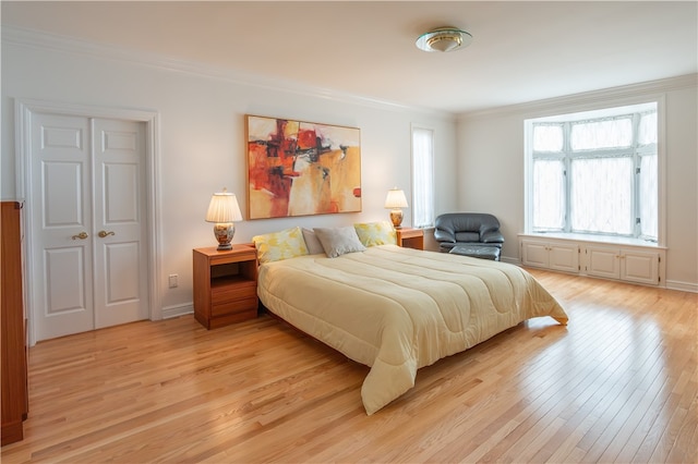 bedroom with ornamental molding and light wood-type flooring