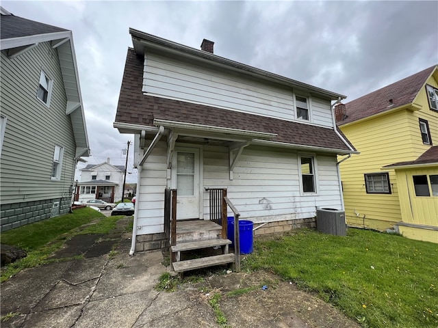 back of house featuring central AC and a yard