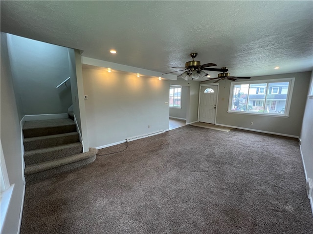 unfurnished living room with carpet floors, ceiling fan, and a textured ceiling