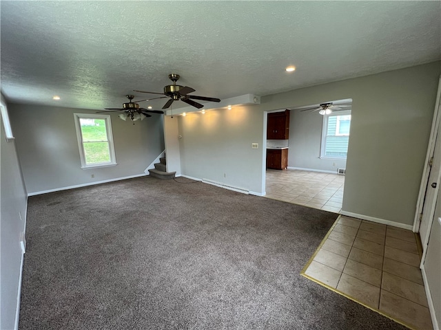 carpeted spare room with ceiling fan and a textured ceiling