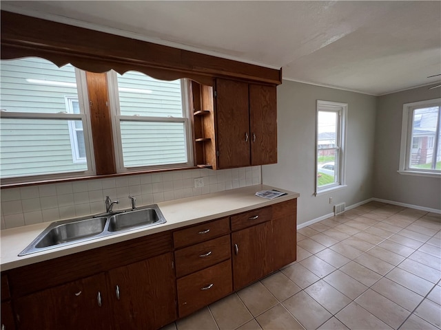 kitchen with light tile patterned flooring, sink, and decorative backsplash