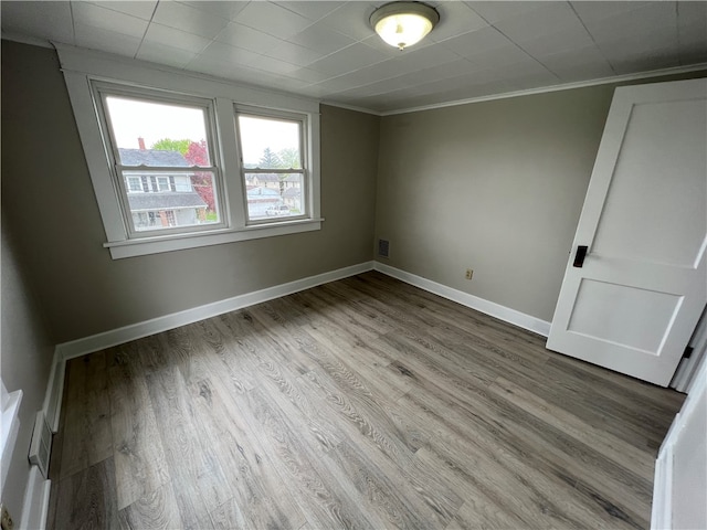 spare room with hardwood / wood-style floors and ornamental molding