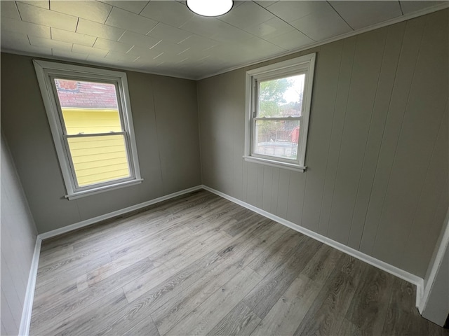 unfurnished room with hardwood / wood-style flooring and crown molding