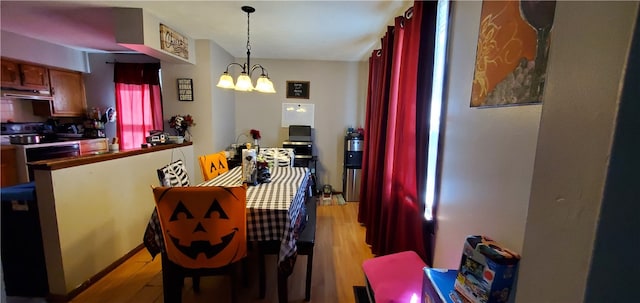 dining area with light hardwood / wood-style floors and a chandelier