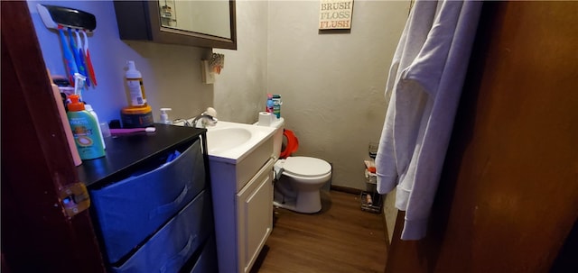 bathroom with wood-type flooring, toilet, and vanity